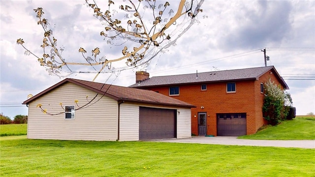 view of front of property with brick siding, a front lawn, driveway, and a chimney
