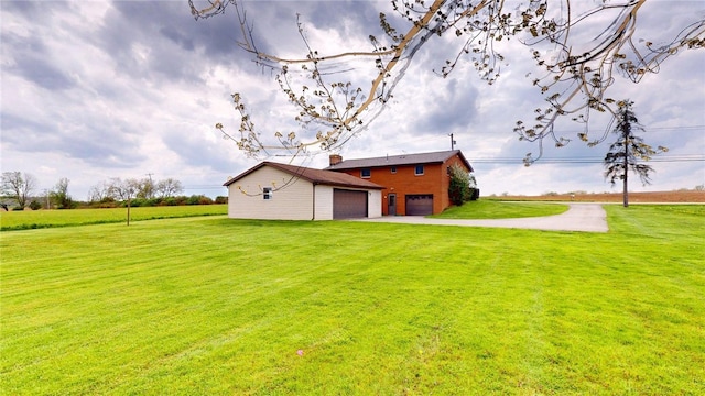 exterior space with an outdoor structure, concrete driveway, and a yard