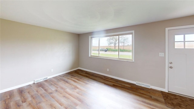 foyer featuring baseboards, visible vents, and light wood-style floors