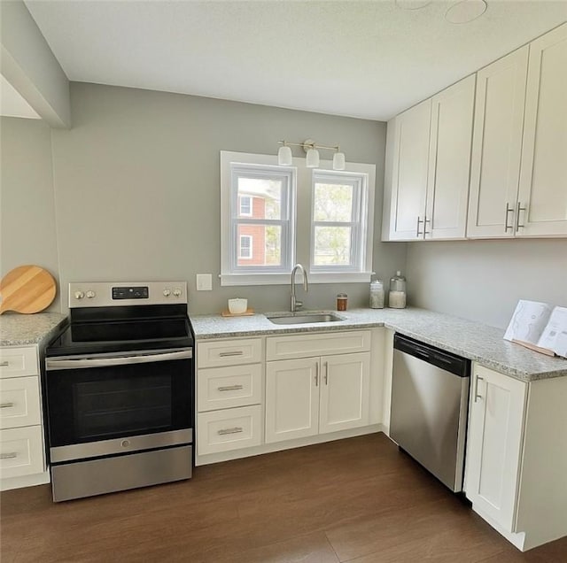 kitchen featuring white cabinets, stainless steel appliances, dark wood-style floors, and a sink