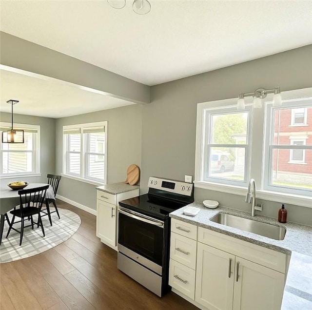 kitchen with dark wood-style floors, a sink, electric stove, white cabinetry, and pendant lighting