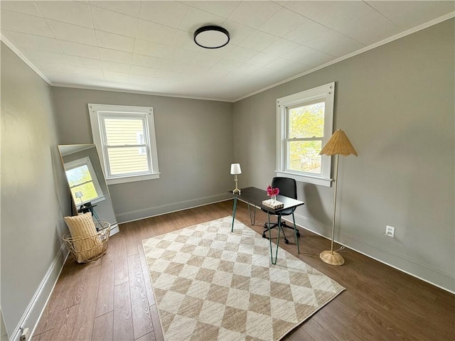 office area featuring a healthy amount of sunlight, baseboards, ornamental molding, and wood finished floors