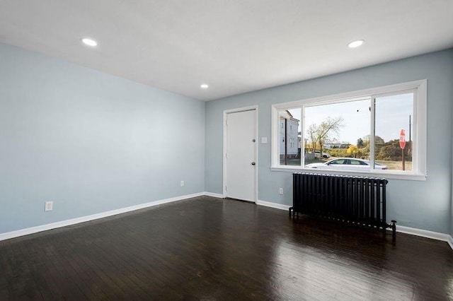 901 Union Ave, Mckeesport, PA 15132 - unfurnished living room with dark wood-style flooring, baseboards, recessed lighting, and radiator