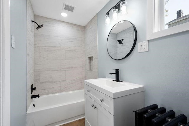 901 Union Ave, Mckeesport, PA 15132 - bathroom featuring visible vents, washtub / shower combination, wood finished floors, and vanity