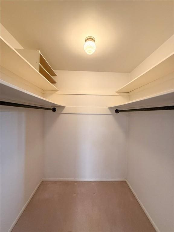 walk in closet featuring light colored carpet