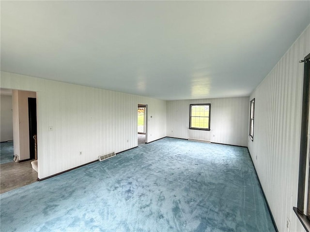 empty room with carpet floors and visible vents