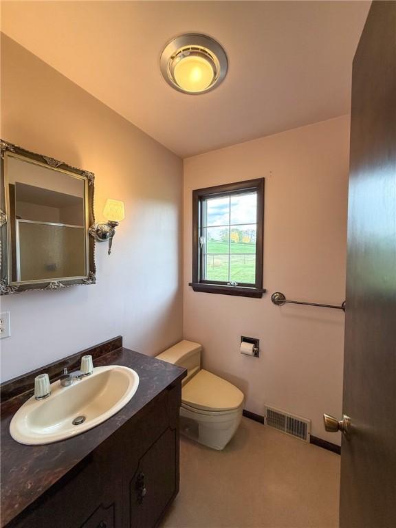 full bath with vanity, walk in shower, toilet, and visible vents