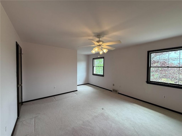 unfurnished room featuring visible vents, baseboards, ceiling fan, and light carpet