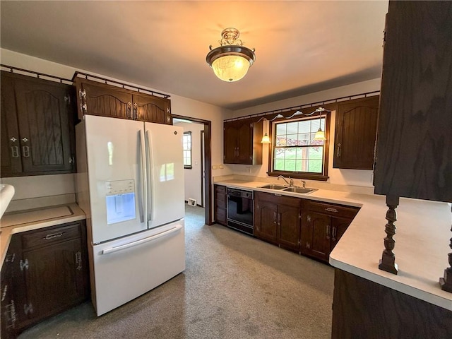 kitchen with dark brown cabinets, a sink, light countertops, white fridge with ice dispenser, and black dishwasher