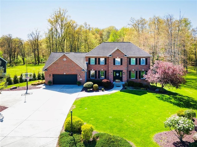 colonial-style house featuring an attached garage, a front yard, driveway, and brick siding