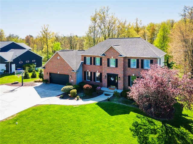 view of front of house with brick siding, an attached garage, driveway, and a front lawn