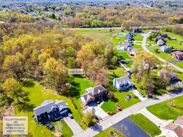 bird's eye view featuring a wooded view and a residential view