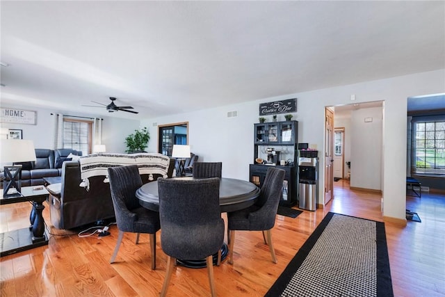 dining space with ceiling fan, visible vents, and light wood finished floors
