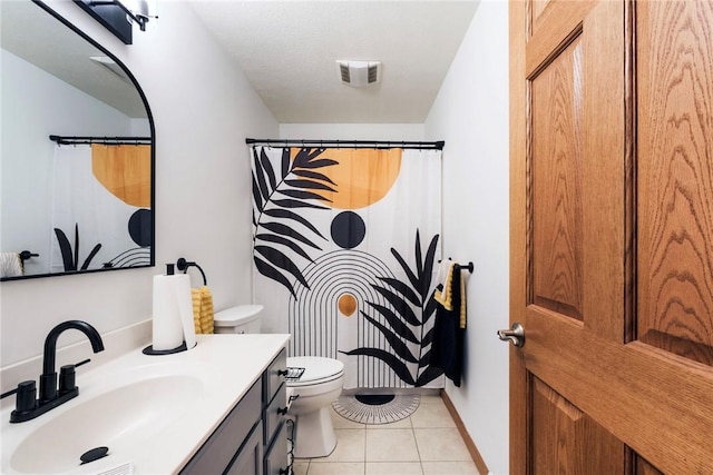 bathroom featuring vanity, toilet, tile patterned floors, baseboards, and visible vents