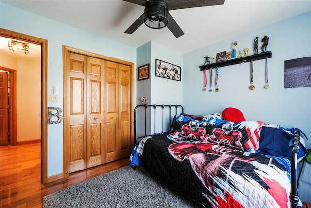 bedroom with a ceiling fan, a closet, and wood finished floors
