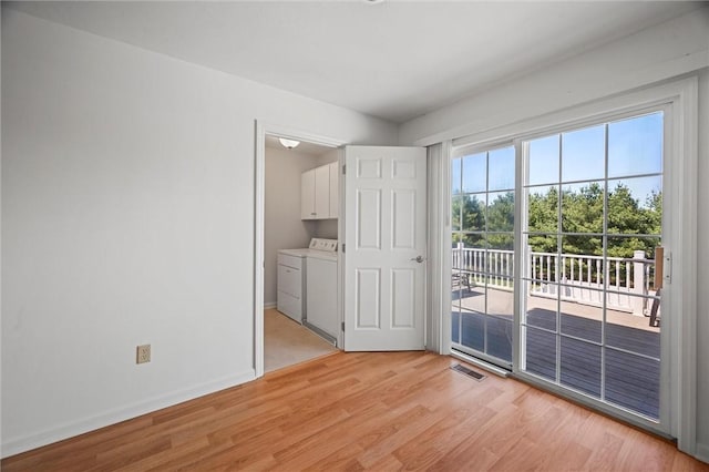 interior space featuring washing machine and dryer, baseboards, access to exterior, and light wood-style flooring