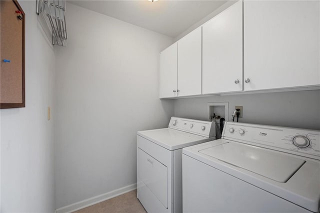 clothes washing area featuring cabinet space, baseboards, and washing machine and dryer
