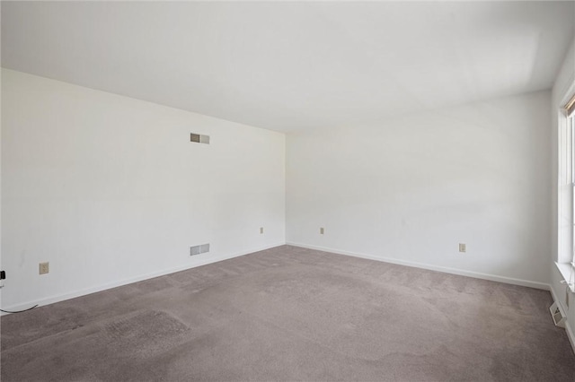 carpeted empty room featuring visible vents and baseboards
