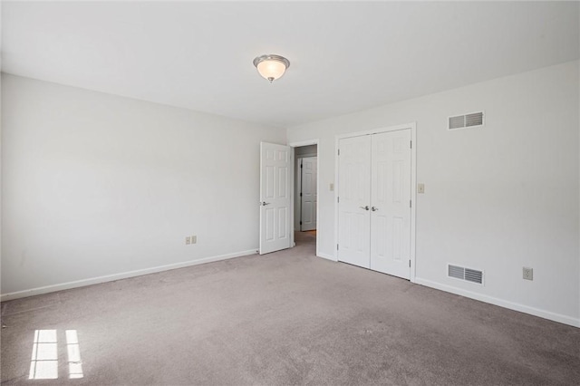 unfurnished bedroom featuring baseboards, visible vents, carpet, and a closet