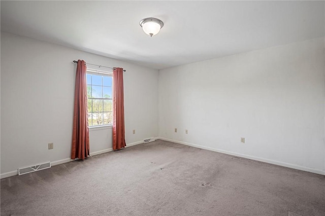 unfurnished room with visible vents, carpet, and baseboards
