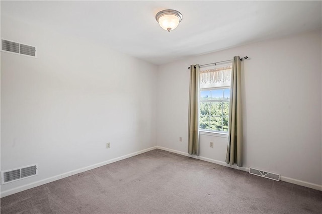 carpeted empty room featuring visible vents and baseboards