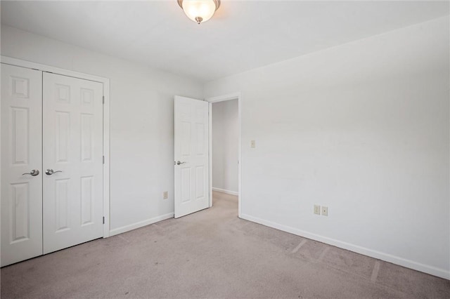 unfurnished bedroom with baseboards, carpet, and a closet