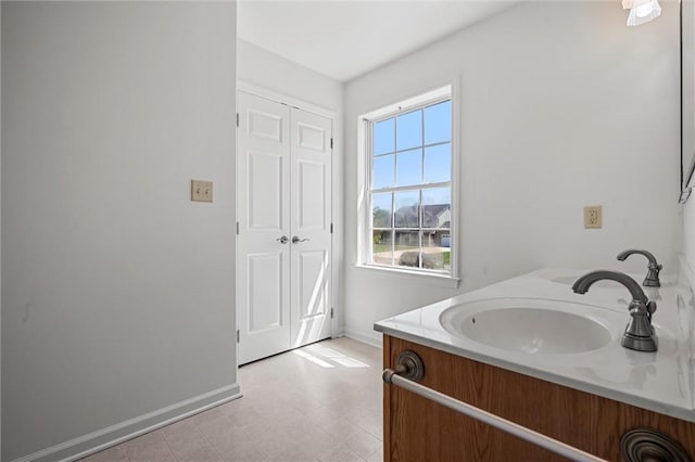 bathroom featuring a sink, baseboards, and double vanity