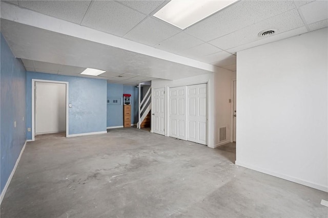 finished basement featuring stairs, baseboards, visible vents, and a drop ceiling