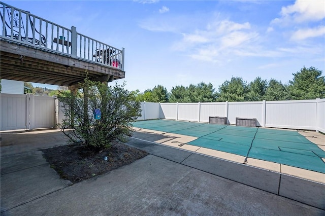 view of swimming pool featuring a patio, fence, a deck, and a fenced in pool
