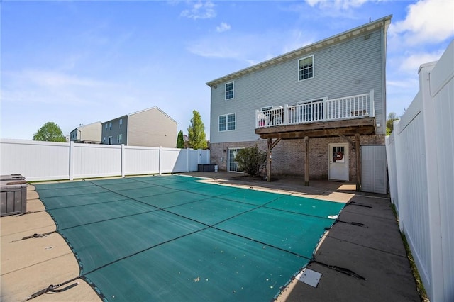 back of property featuring brick siding, a fenced in pool, and a fenced backyard