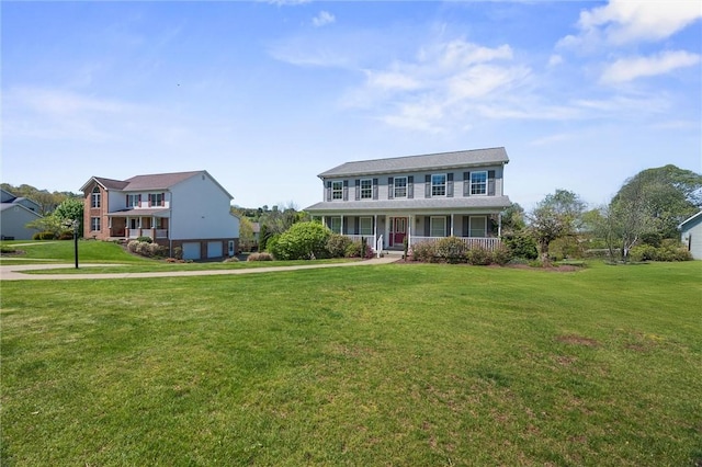 view of front of home with covered porch, an attached garage, driveway, and a front yard