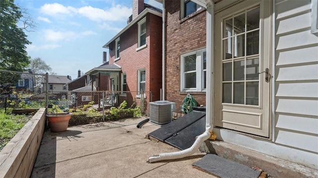 view of patio / terrace featuring fence, central AC, and a residential view