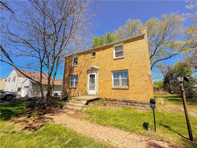 2103 Oriole Dr, Hopewell Twp Bea, PA 15001 - view of front of house with brick siding, a chimney, and a front lawn