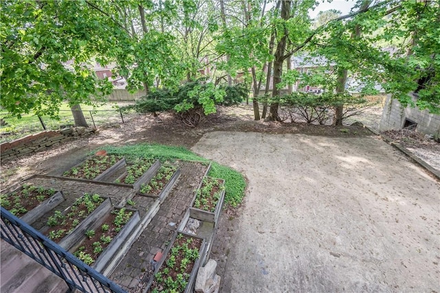 view of yard featuring fence and a vegetable garden