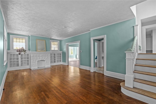unfurnished living room with a textured ceiling, baseboards, stairs, and wood finished floors