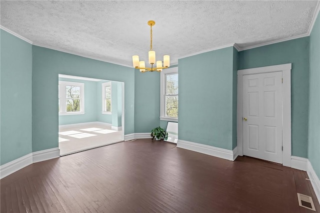 unfurnished room with visible vents, wood-type flooring, crown molding, baseboards, and a chandelier
