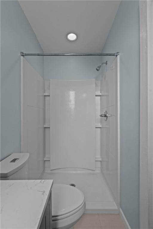 bathroom with vanity, toilet, tile patterned flooring, and a shower