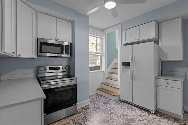 kitchen with ceiling fan, white cabinets, and stainless steel appliances