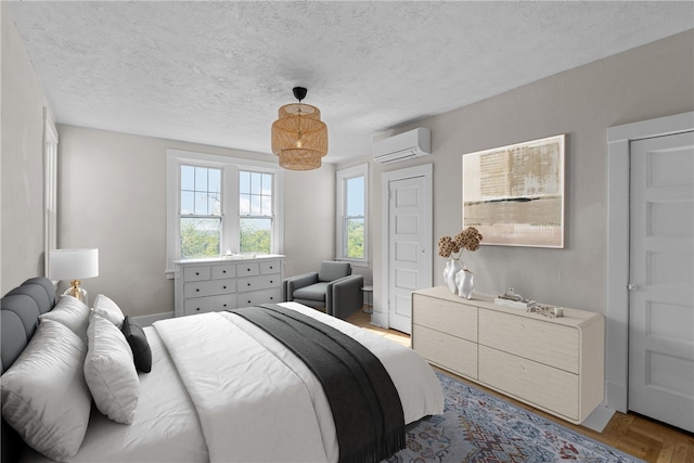 bedroom featuring an AC wall unit and a textured ceiling