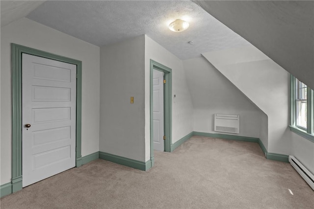 additional living space with carpet floors, baseboards, a wall unit AC, and baseboard heating