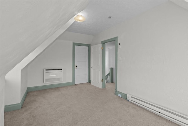 additional living space featuring heating unit, vaulted ceiling, a baseboard heating unit, and carpet flooring