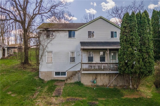 back of house featuring a yard and a shingled roof