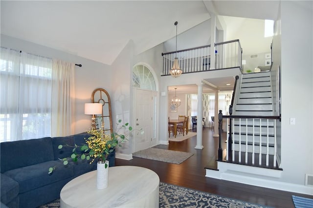 living room with an inviting chandelier, wood finished floors, baseboards, stairway, and plenty of natural light