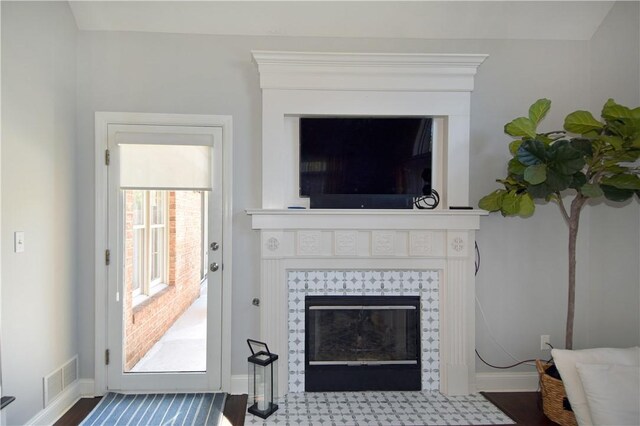 interior details featuring baseboards, visible vents, and a tile fireplace