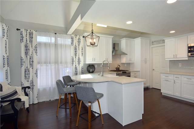 kitchen with recessed lighting, wall chimney exhaust hood, white cabinetry, appliances with stainless steel finishes, and backsplash