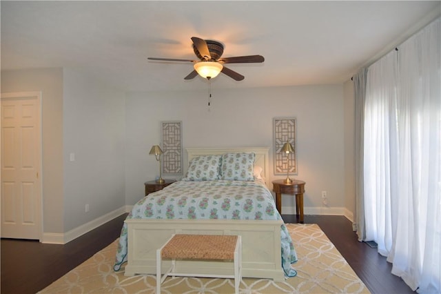 bedroom with baseboards, a ceiling fan, and dark wood-style floors