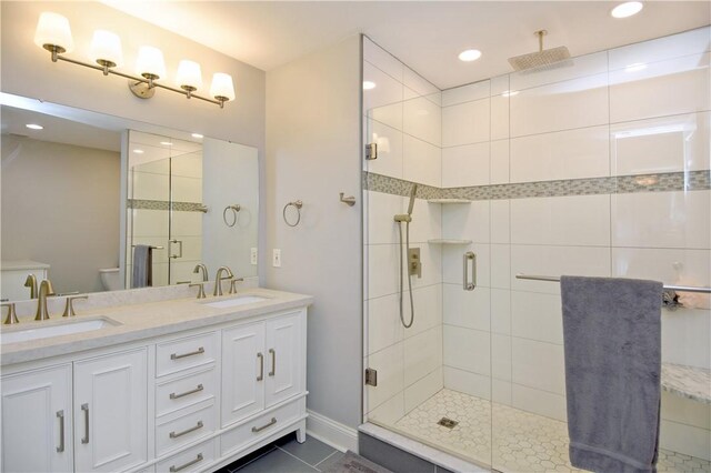full bath featuring a sink, a shower stall, toilet, and double vanity