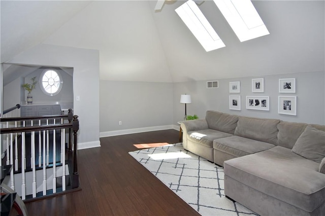 living room featuring visible vents, baseboards, lofted ceiling with skylight, and wood finished floors