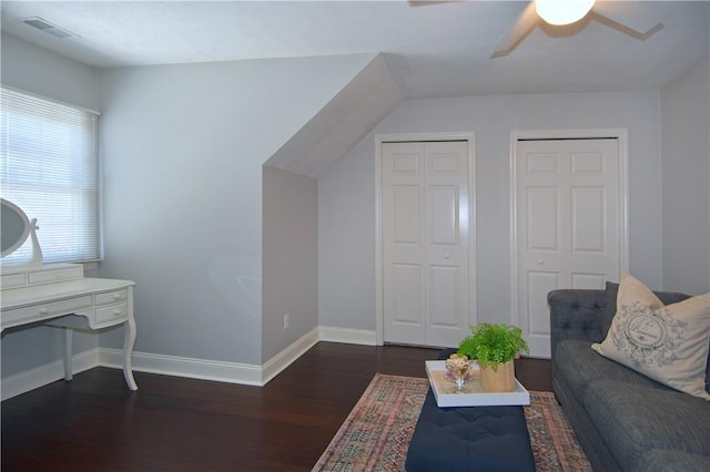 living area featuring visible vents, a ceiling fan, baseboards, and wood finished floors