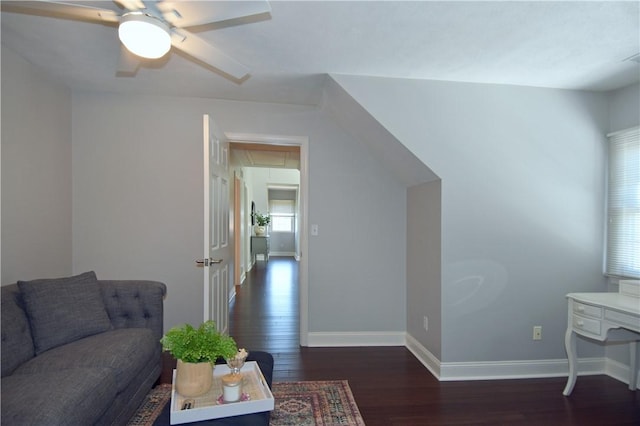 living room with a ceiling fan, baseboards, wood finished floors, and attic access
